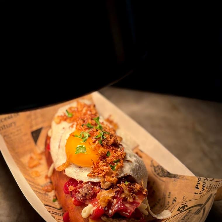 Le Complet : œuf au plat et bacon caramélisé sur un hot dog maison