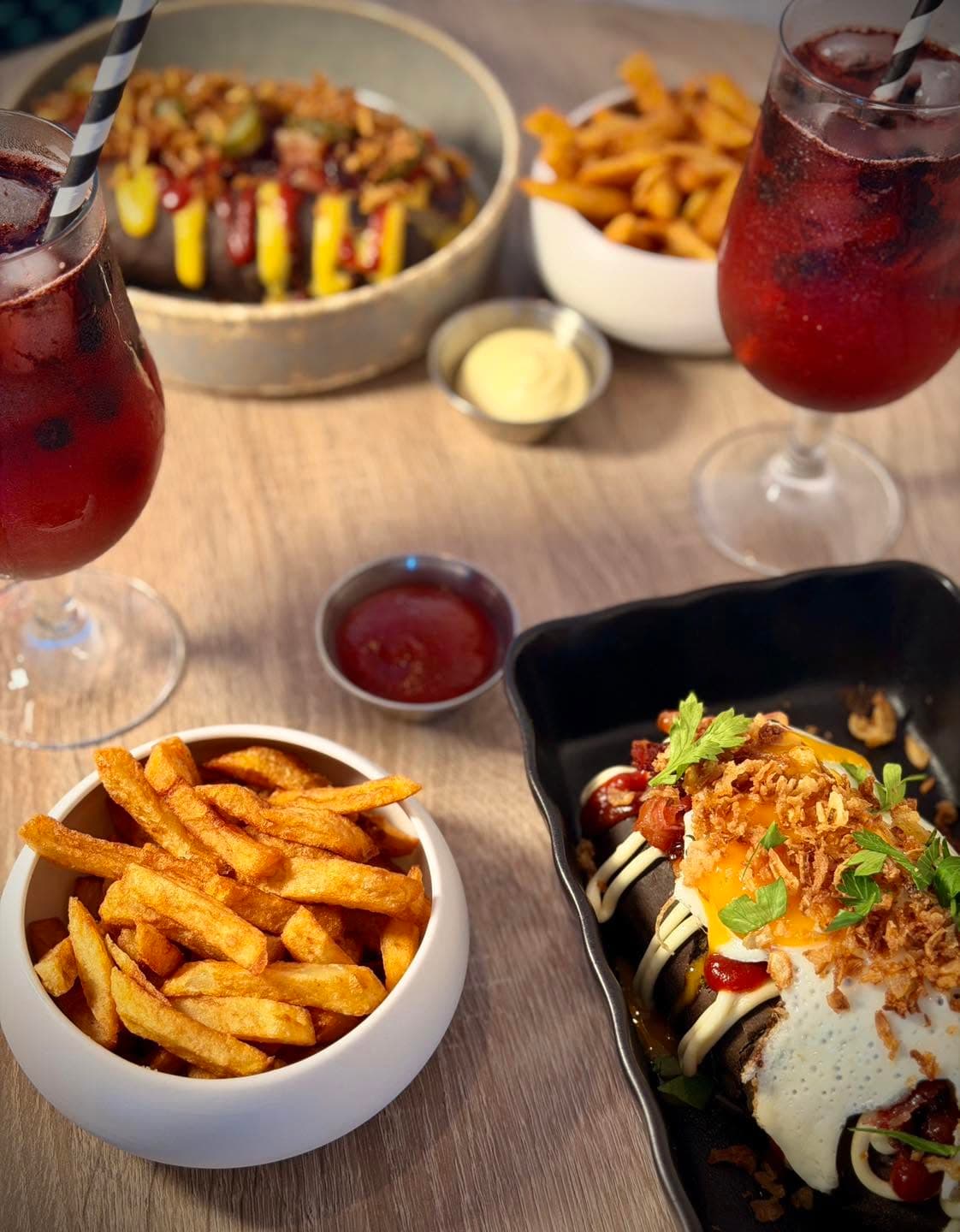Table garnie de hot dogs, frites maison et boissons